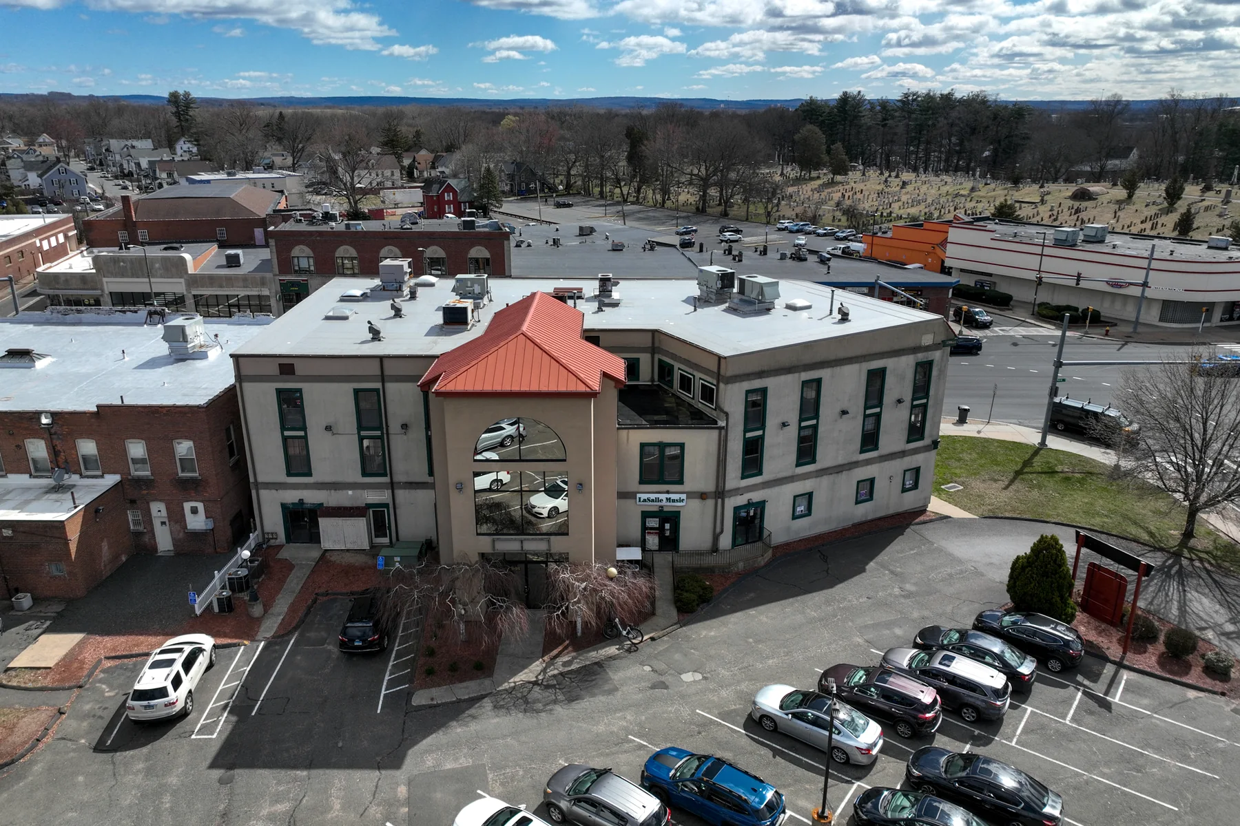 Aerial photography shows the building's scale, parking, and surrounding street network.