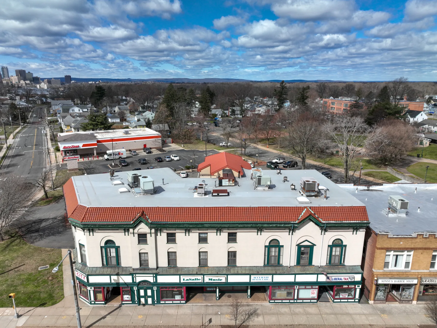 A high rear view documents the roof, service access, parking, and full depth of the property.