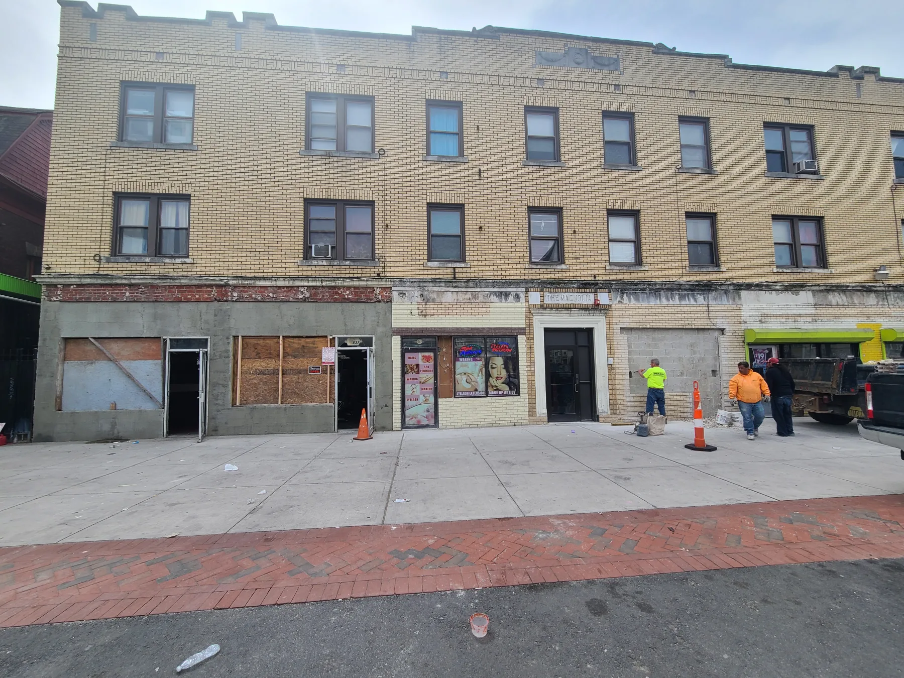 The original frontage shows boarded openings and the starting condition of the rehabilitation.