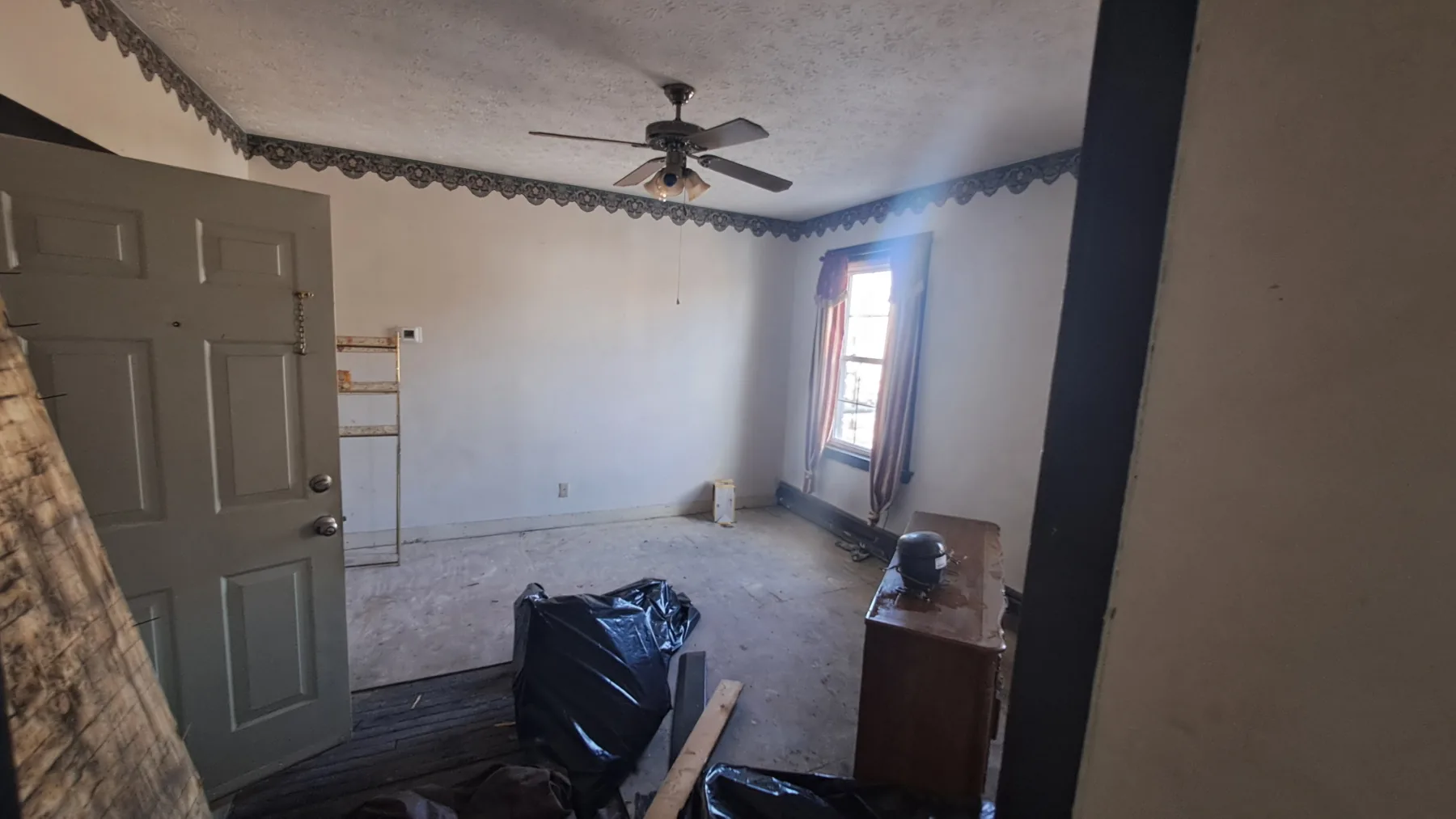 An apartment interior records the dated finishes and room condition before unit-level improvements.