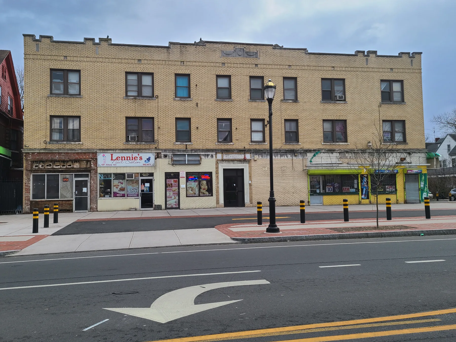 A full pre-renovation view records the mismatched storefronts and weathered street-level façade.