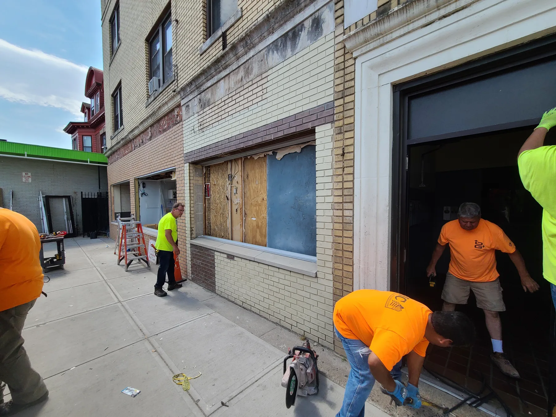 New storefront openings, doors, and glazing begin to replace the boarded and enclosed bays.
