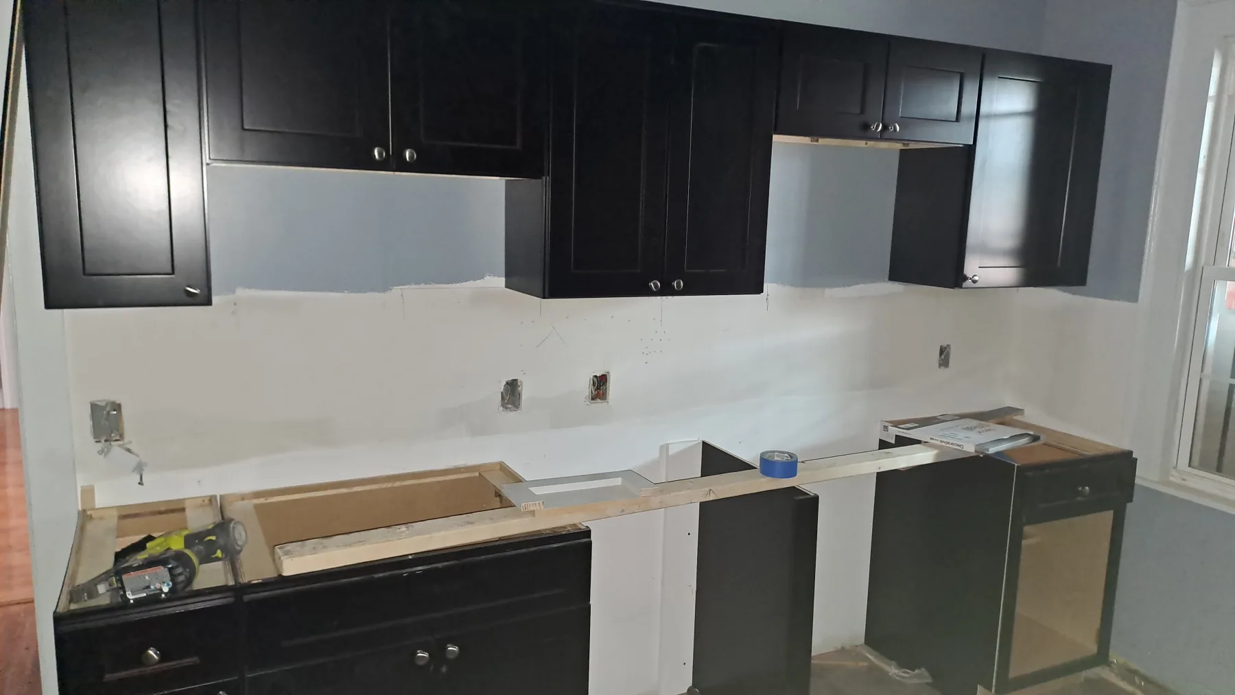 Cabinets are set while counters, fixtures, and finish work are still in progress.