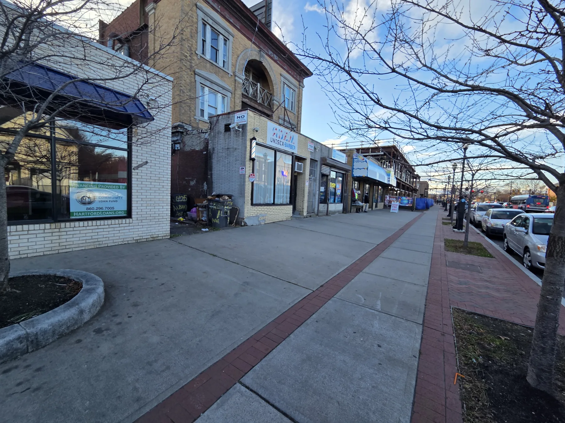 A wider completed view shows how the renewed storefront now participates in the surrounding commercial corridor.