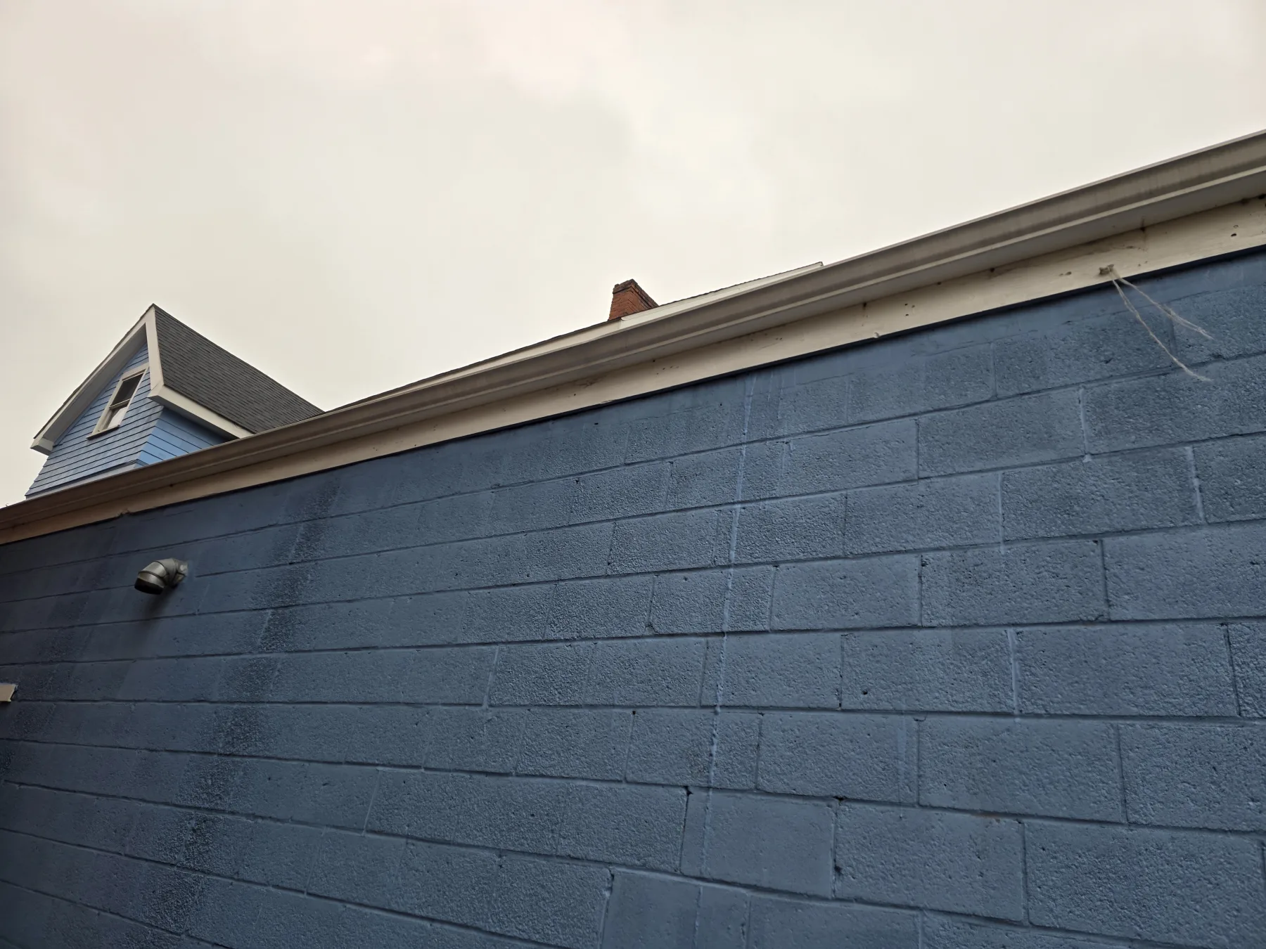 Work along the side wall and roof edge documents repairs to the exterior envelope.