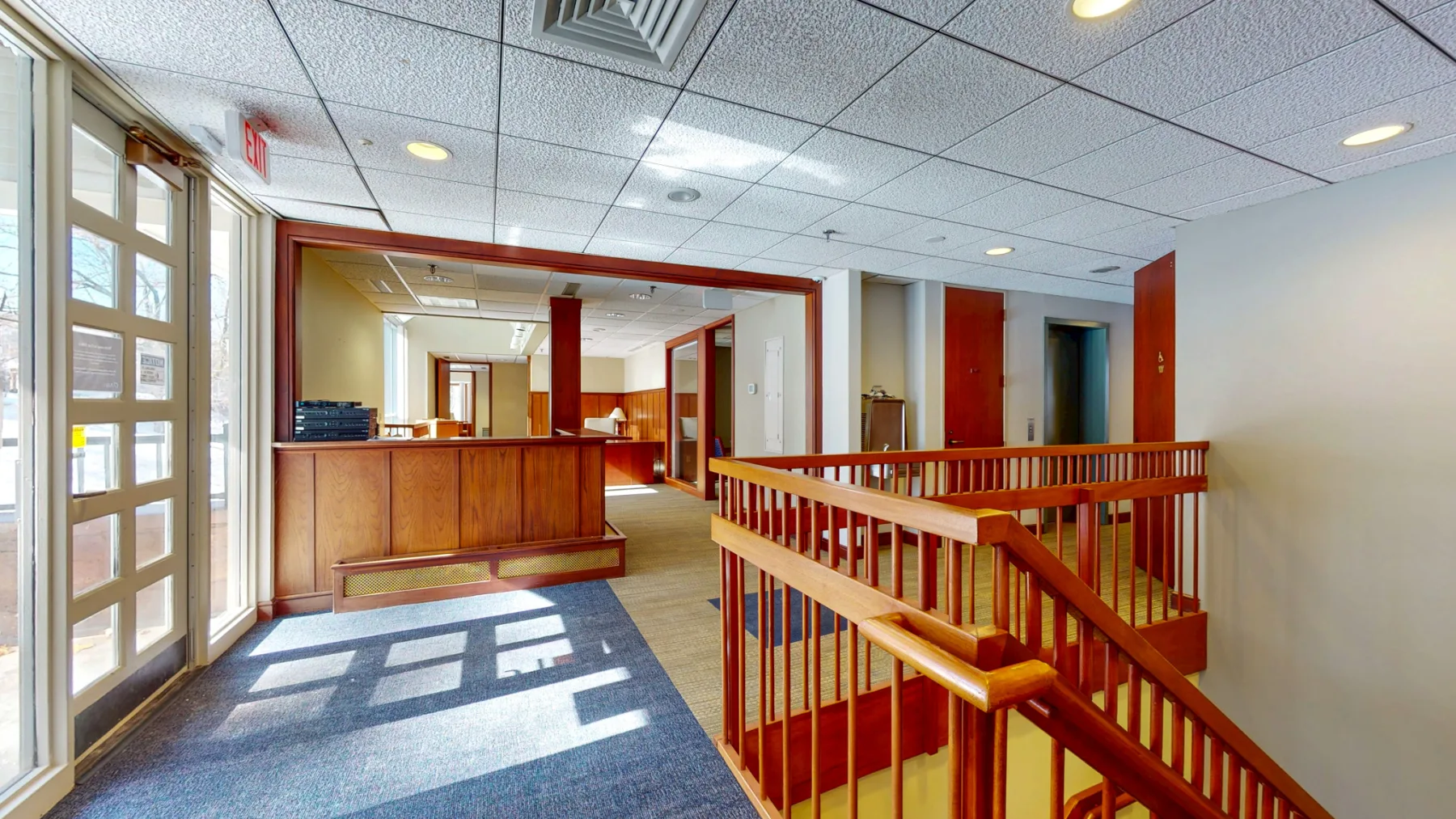 The reception area creates a warm, professional arrival with wood detailing and natural light.