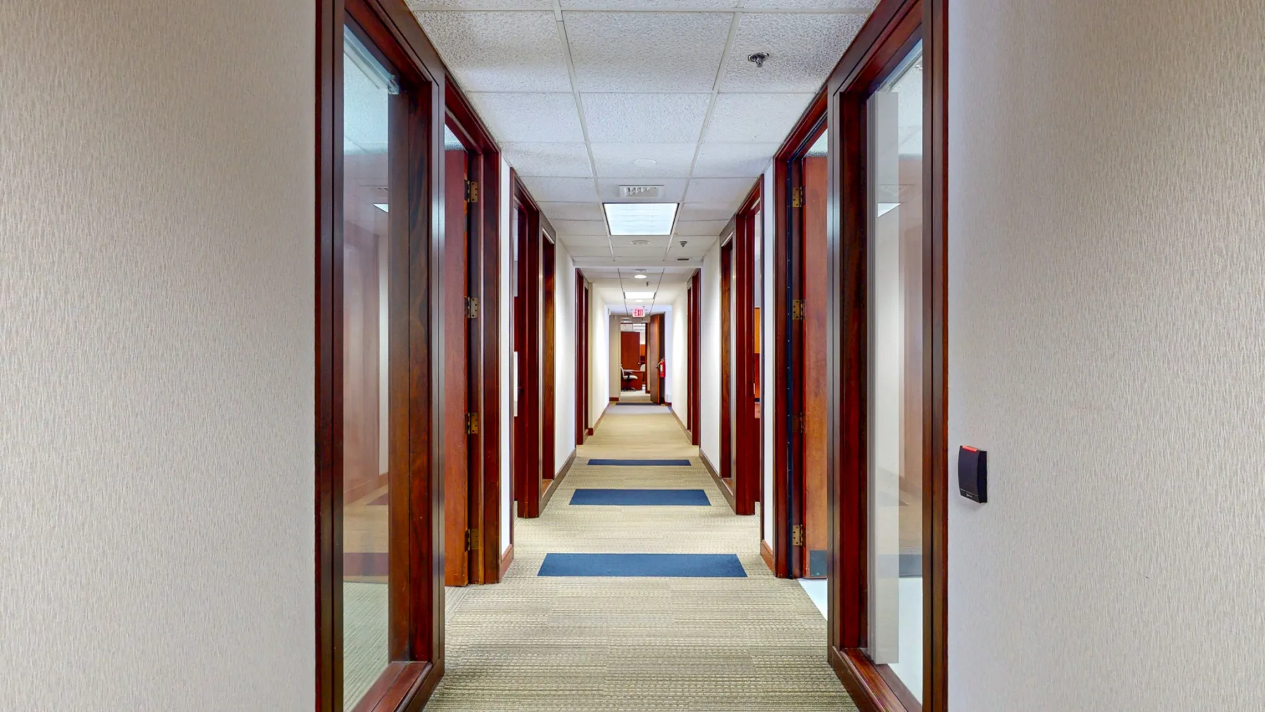 The final interior view follows the glass-lined corridor connecting the individual offices.