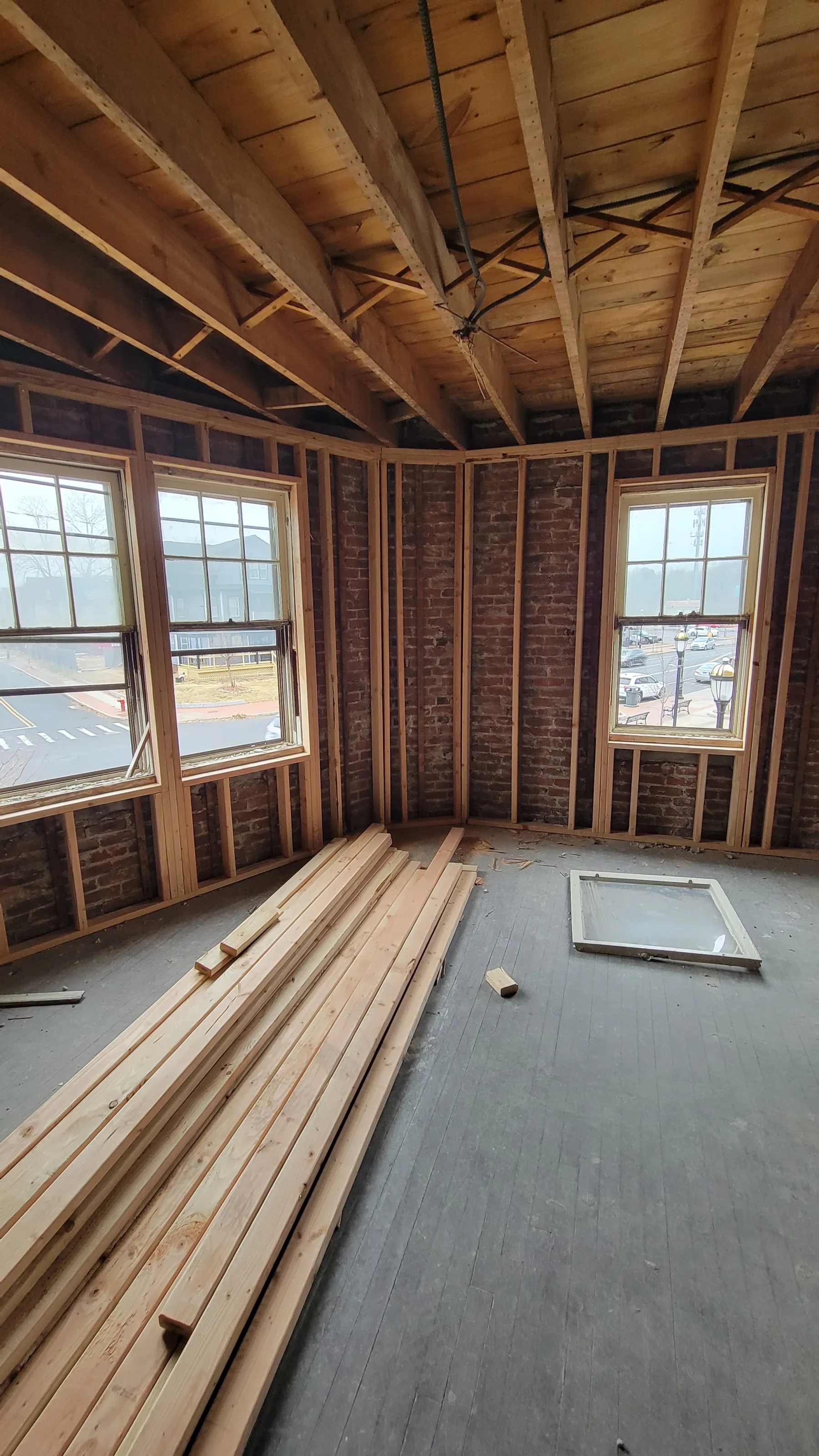 New interior framing is built within the exposed brick shell as rooms and building systems take shape.