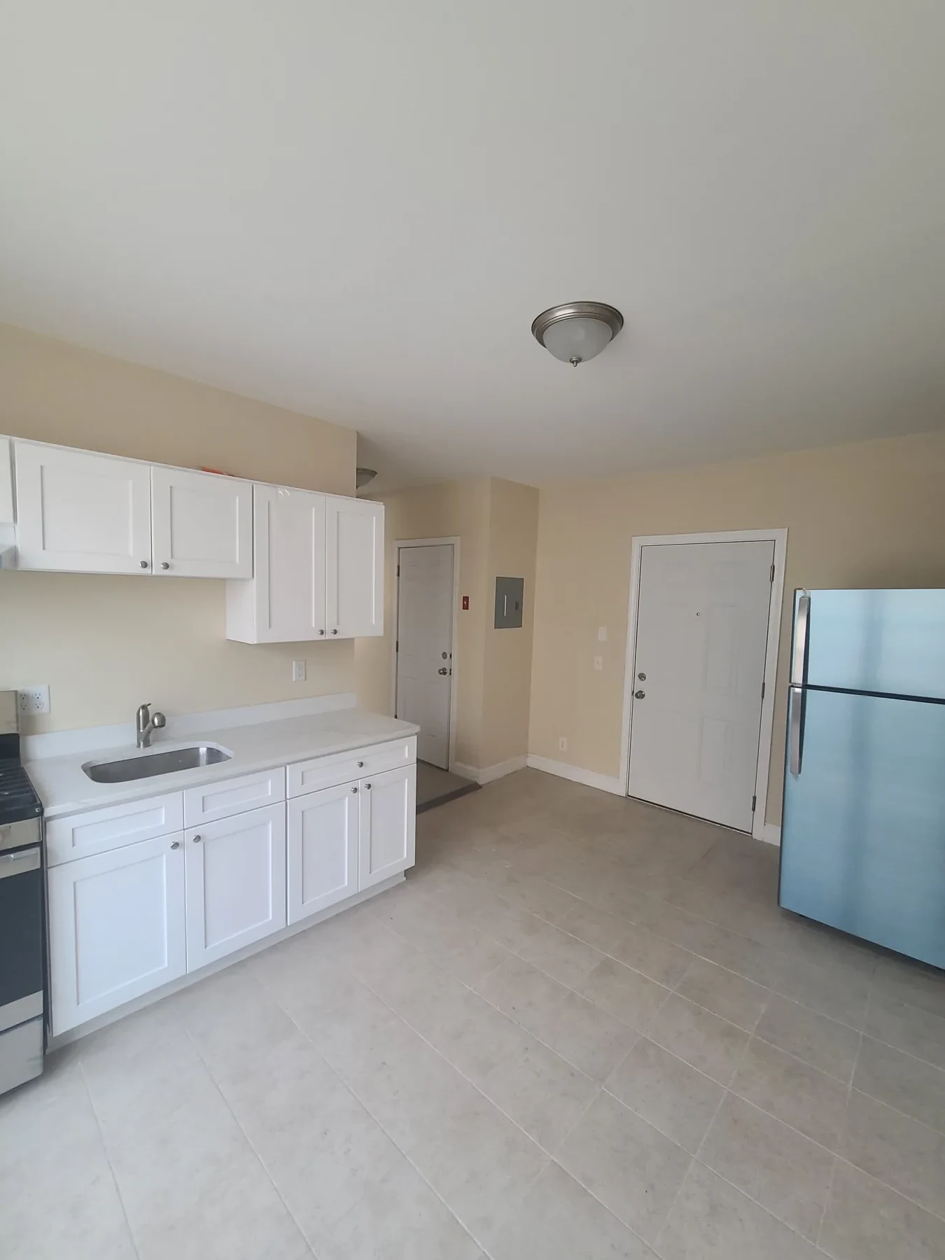 The completed apartment brings together the kitchen, appliances, flooring, and living area.