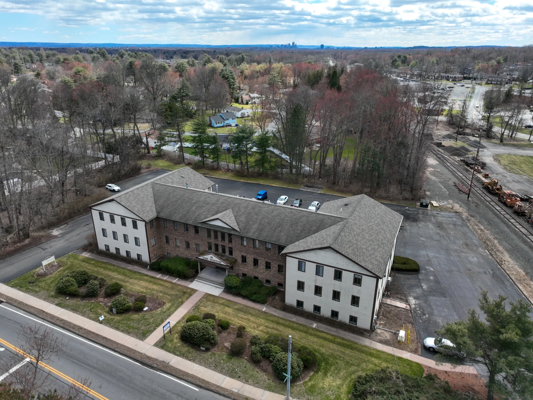 A second aerial shows the complete front elevation, entrance walk, parking, and surrounding site.