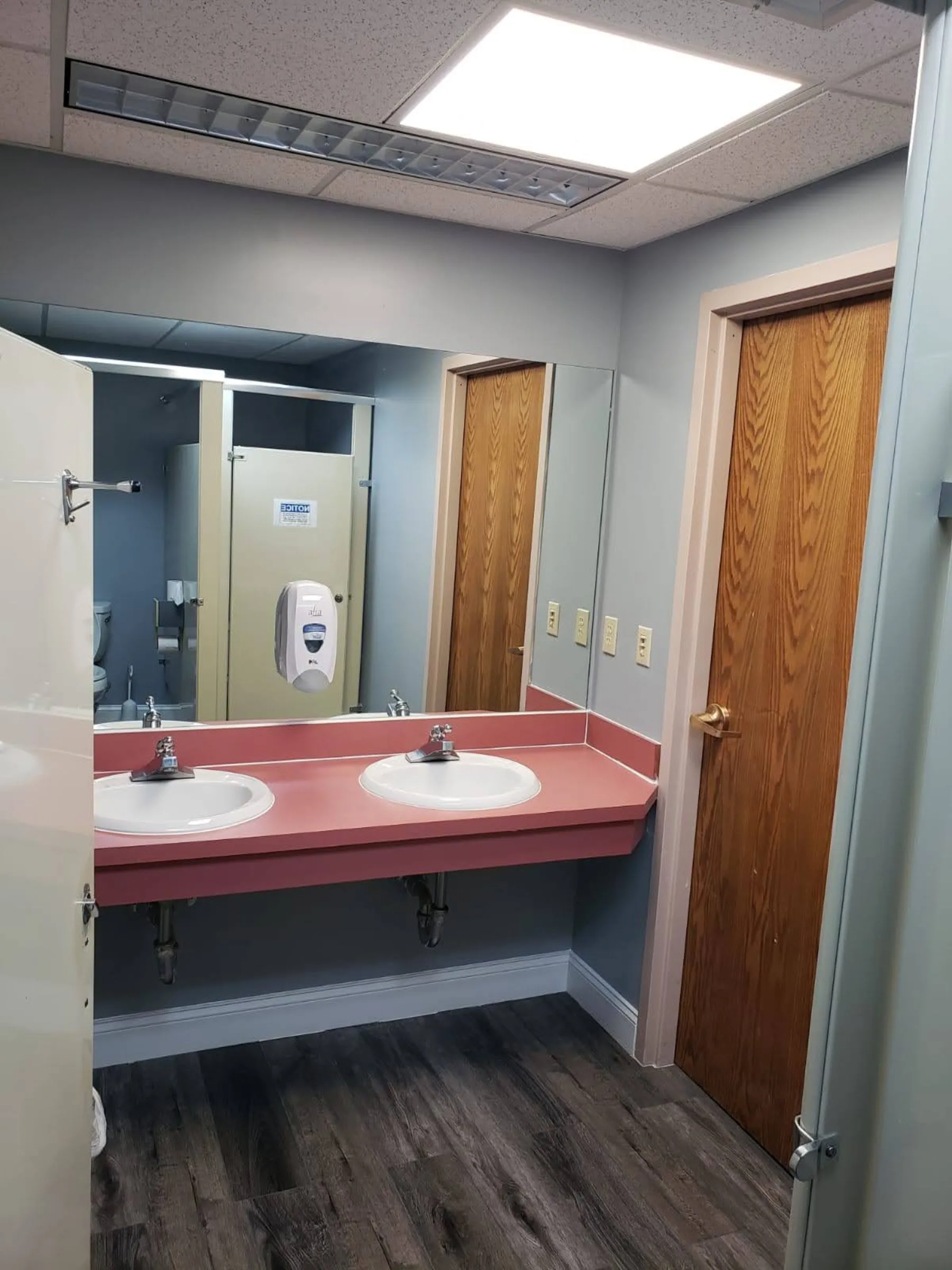 A refreshed shared restroom extends the flooring and paint improvements into support spaces.
